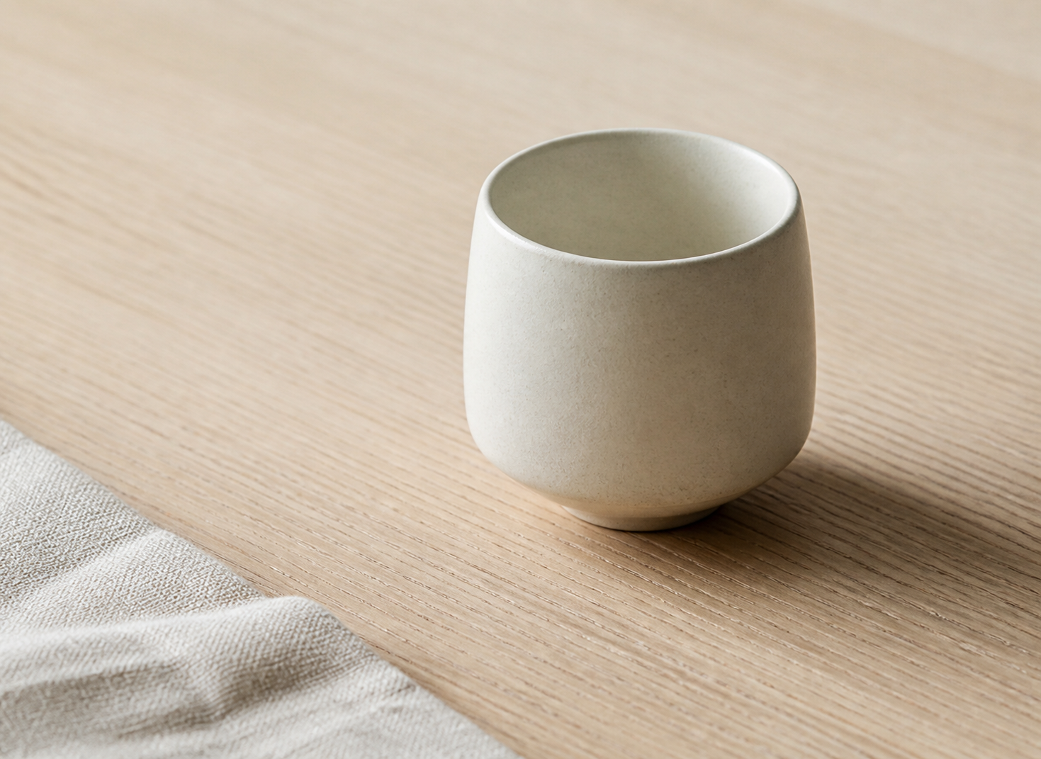 Ceramic cup on a pale oak table in morning light
